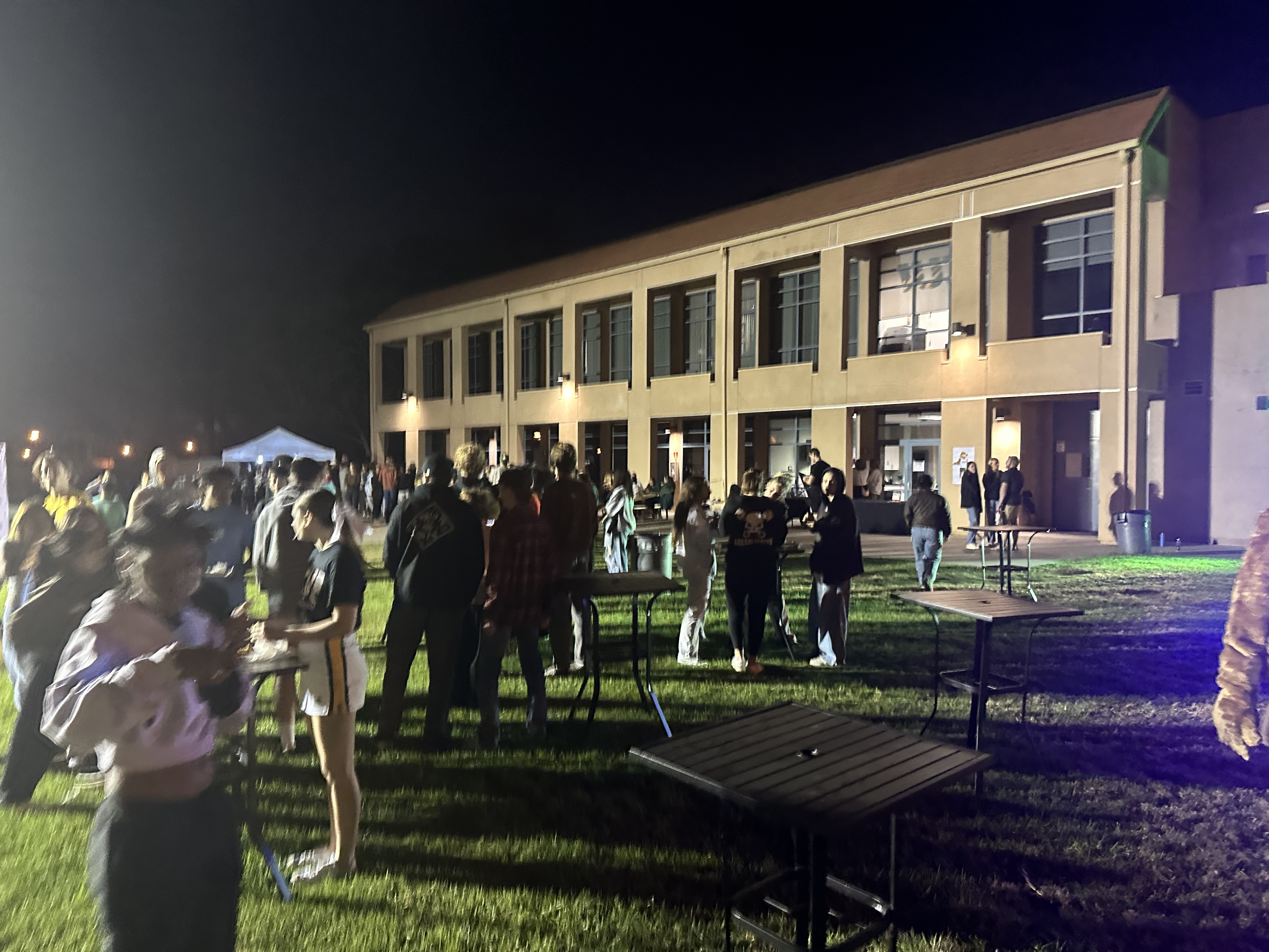 Students standing outside CU Arena during Midnight Madness outdoor party.